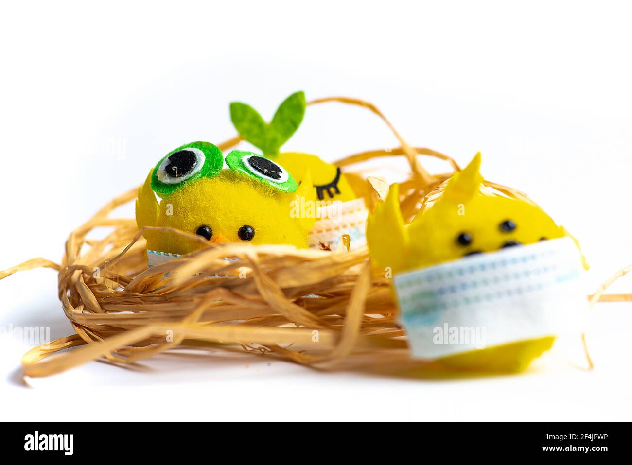 Baby Spielzeug Huhn trägt chirurgische Gesichtsmaske auf weißem Hintergrund mit Kopie Raum. Covid-19 Pandemie und feiern Feiertage mit Coronavirus abstrakt Stockfoto