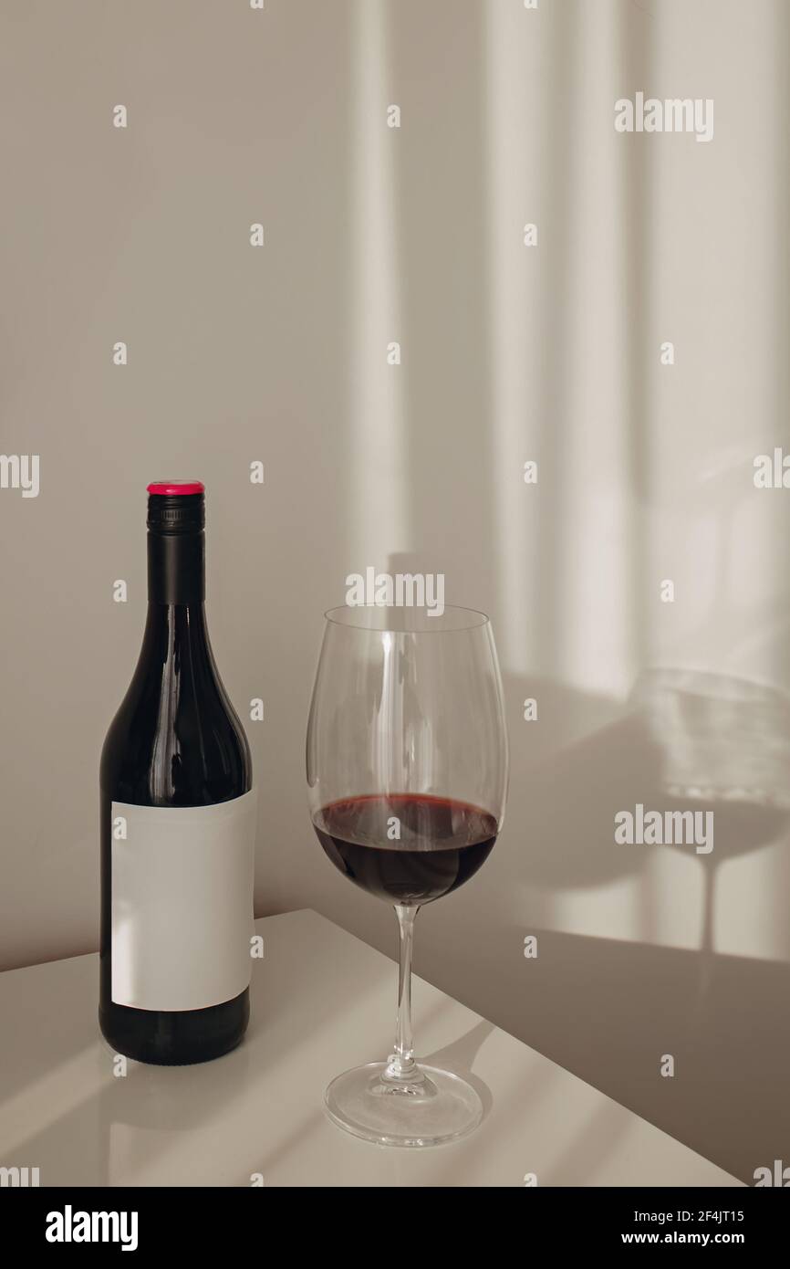 Eine Flasche und ein Glas Rotwein auf dem weißen Tabelle Stockfoto