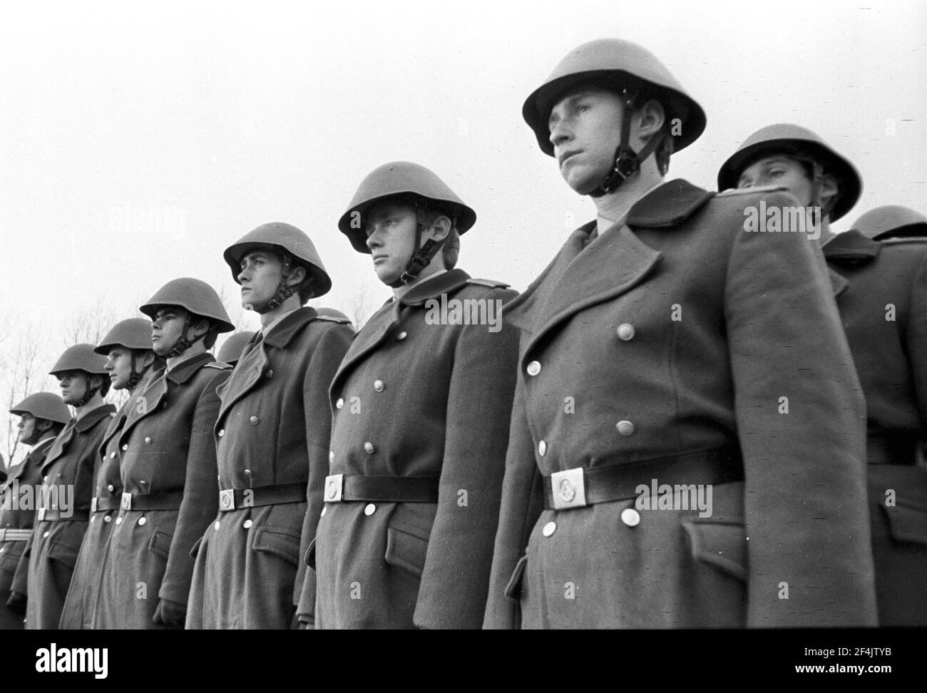 20. November 1981, Sachsen, Delitzsch: Mit Stahlhelm eingesiedelt - Junge Soldaten der NVA werden Ende 1981 auf einem Sportplatz im Dorf Glesien vereidigt. Eltern, Verwandte, Bekannte und die Bevölkerung beteiligen sich. Genaues Aufnahmedatum nicht bekannt. Foto: Volkmar Heinz/dpa-Zentralbild/ZB Stockfoto