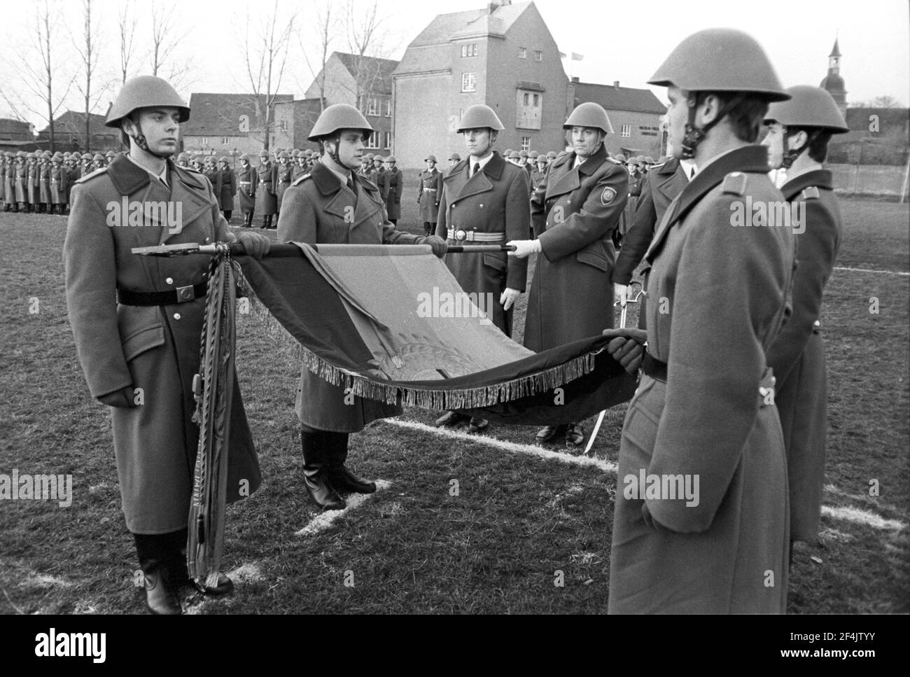 20. November 1981, Sachsen, Delitzsch: Pfand und Eid bei der Truppenflagge. Die jungen Soldaten der NVA werden Ende 1981 auf einem Sportplatz im Dorf Glesien vereidigt. Eltern, Verwandte, Bekannte und die Bevölkerung nehmen Teil. Genaues Aufnahmedatum nicht bekannt. Foto: Volkmar Heinz/dpa-Zentralbild/ZB Stockfoto