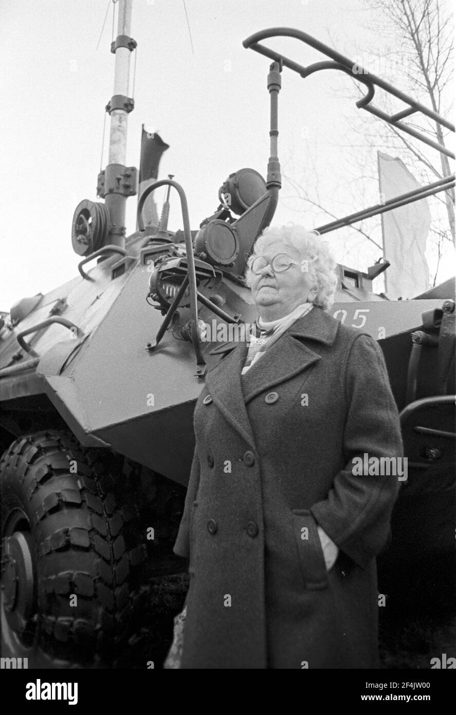 20. November 1981, Sachsen, Delitzsch: Ältere Frau vor einem gepanzerten Personenwagen (SPC) - Junge Soldaten der NVA werden Ende 1981 auf einem Sportplatz in Glesien vereidigt. Eltern, Verwandte, Bekannte und die Bevölkerung nehmen Teil. Genaues Aufnahmedatum nicht bekannt. Foto: Volkmar Heinz/dpa-Zentralbild/ZB Stockfoto