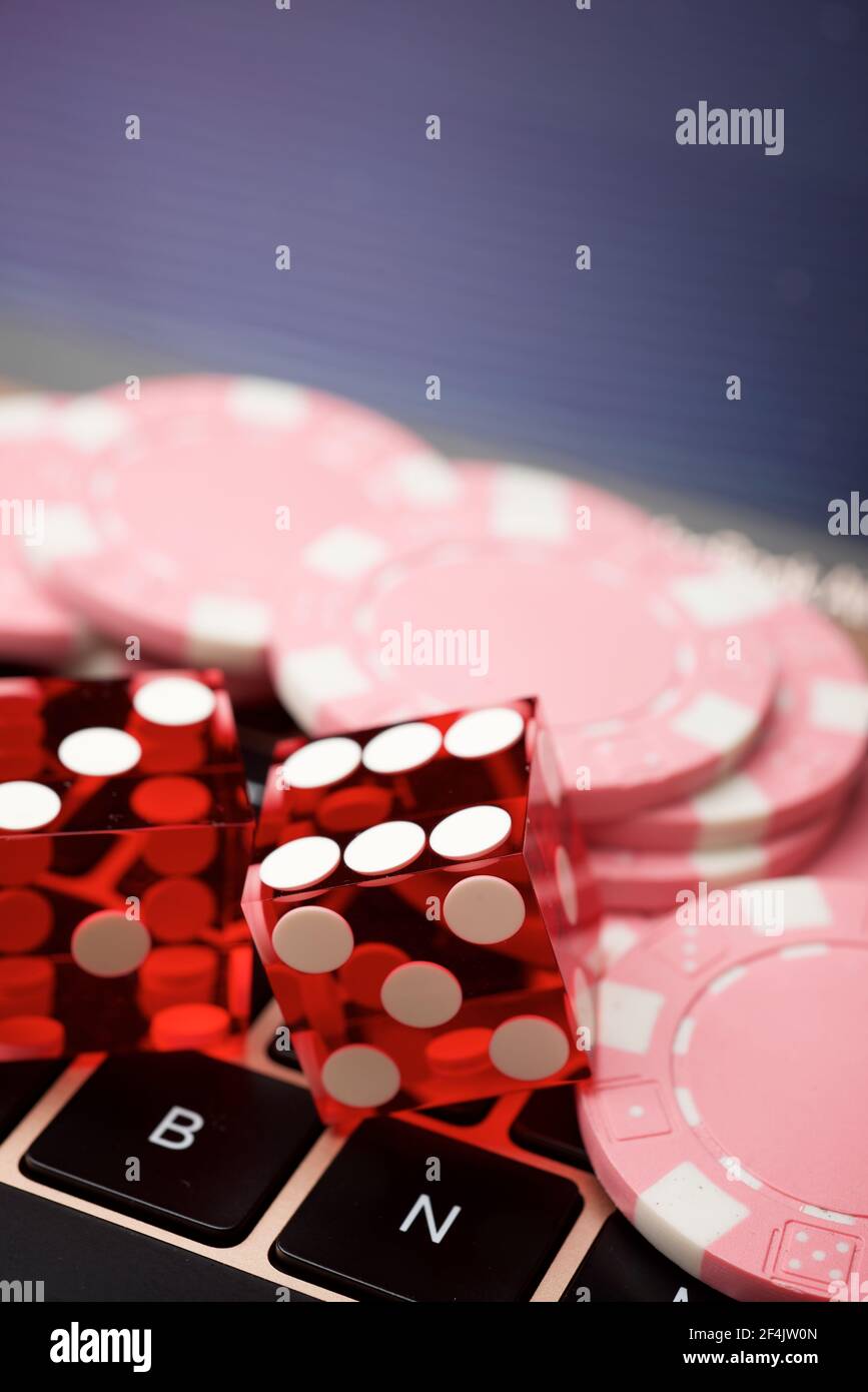 Casino Chips und Würfel Stapeln auf einem Laptop. Stockfoto
