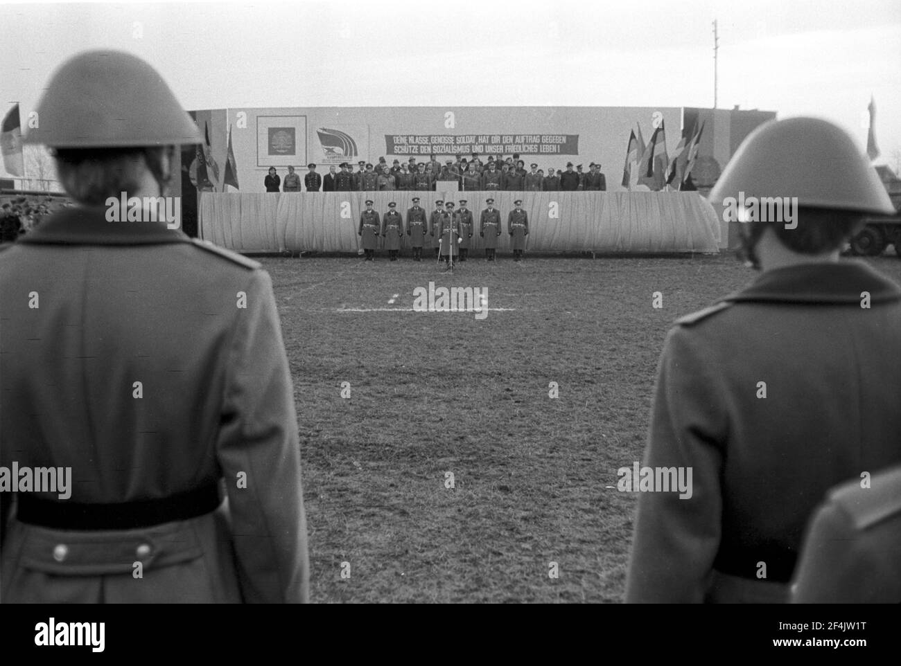 20. November 1981, Sachsen, Delitzsch: Slogan: "Deine Klasse, Genosse Soldat, hat dir den Befehl gegeben - schütze den Sozialismus und unser friedliches Leben!" . Die jungen Soldaten der NVA werden Ende 1981 auf einem Sportplatz im Dorf Glesien vereidigt. Eltern, Verwandte, Bekannte und die Bevölkerung nehmen Teil. Genaues Aufnahmedatum nicht bekannt. Foto: Volkmar Heinz/dpa-Zentralbild/ZB Stockfoto