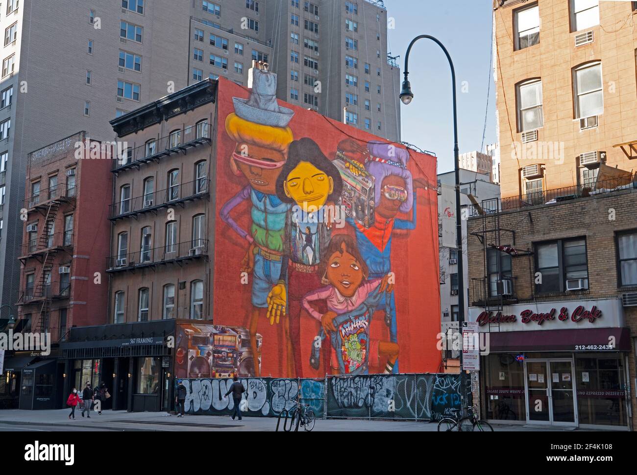 Wandgemälde der Zwillingsbrüder Otavio und Gustavo Pandolfo, Straßenkünstler, die sich OS Gemeos nennen, flankieren ein leeres Grundstück in der 14th Street in Manhattan. Stockfoto
