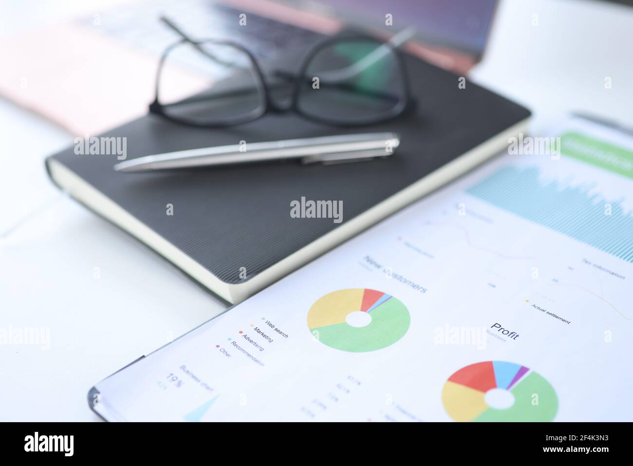 Finanzdokumente mit Geschäftskennzahlen mit Tagebuch und Brille sind Auf dem Tisch Stockfoto