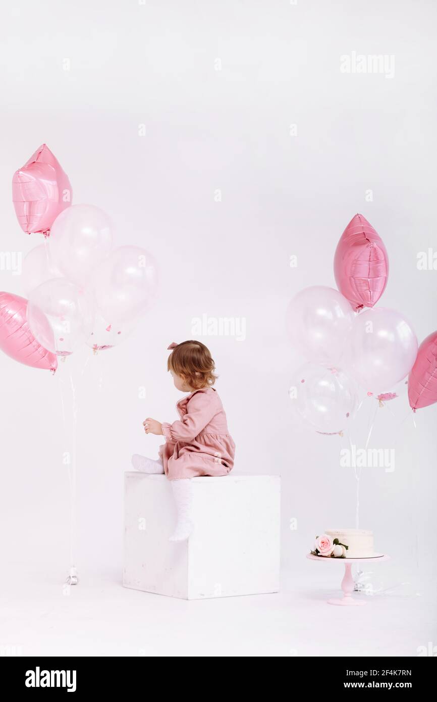 Alles gute zum Geburtstag 2 Jahre alte kleine Mädchen in rosa Kleid. Weißer Kuchen mit Kerzen