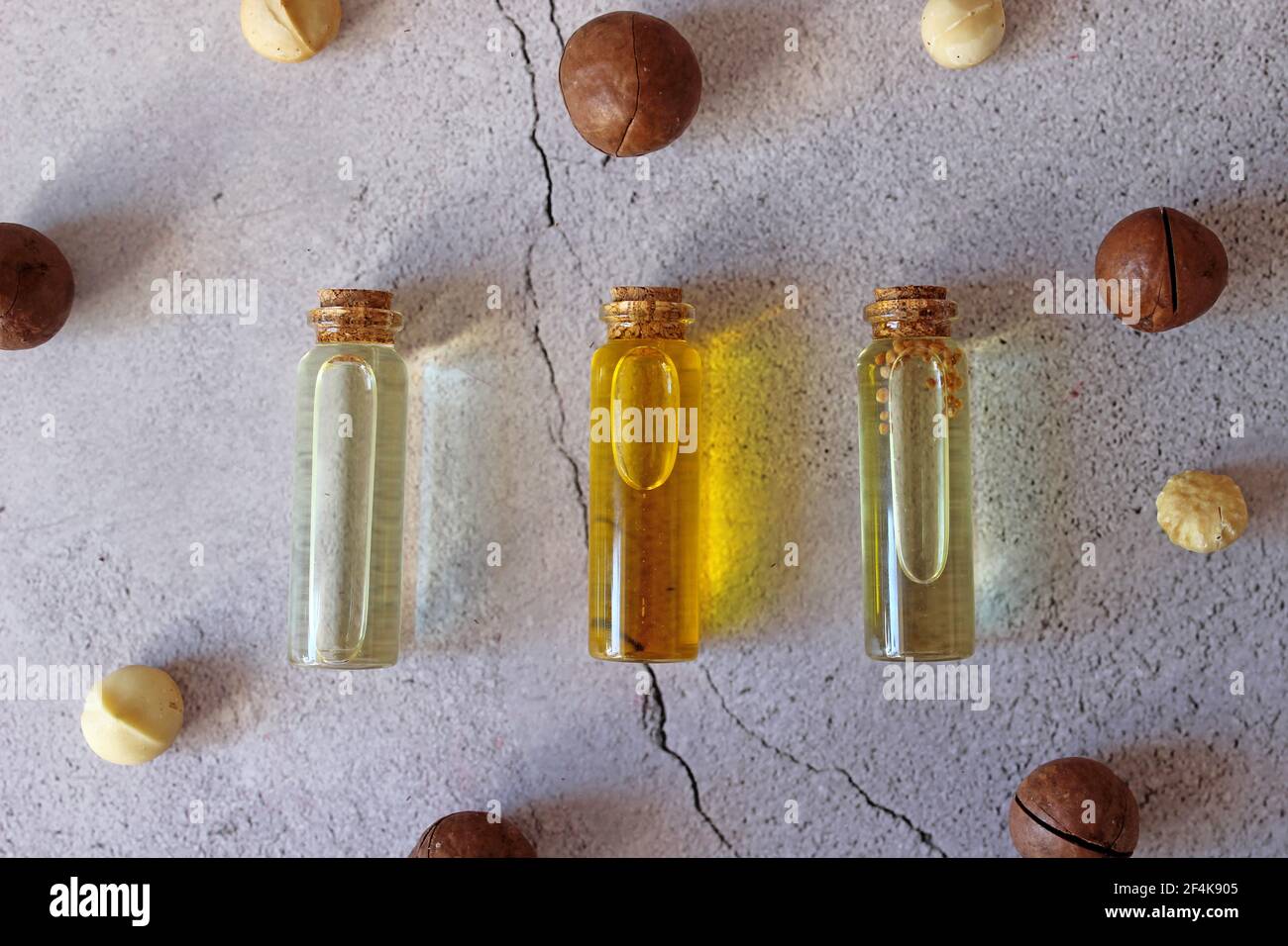 Nahaufnahme von natürlichem Macadamiaöl und Macadamianüssen auf Steinplatte. Gesundes Produkt. Stockfoto
