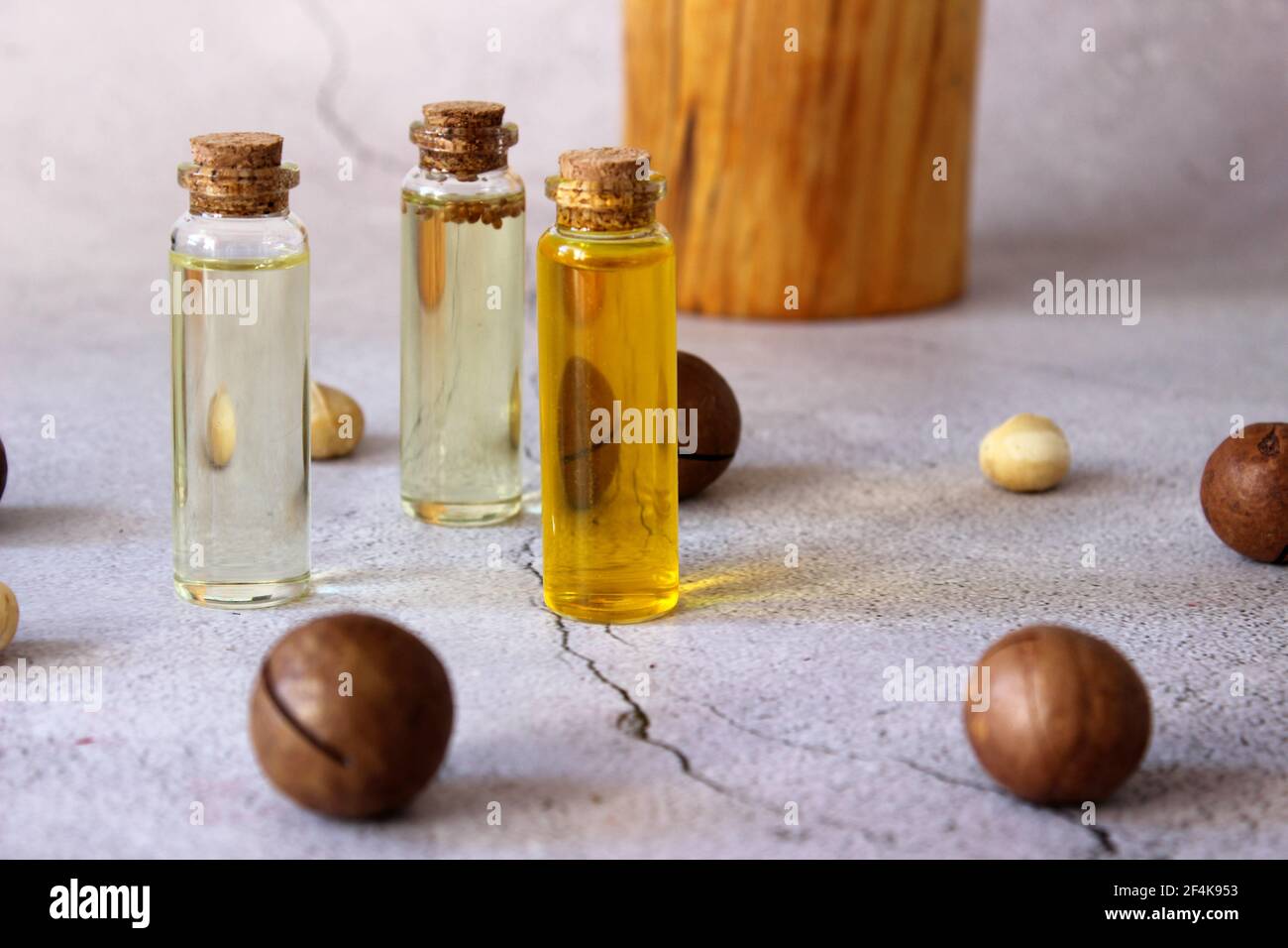 Nahaufnahme von natürlichem Macadamiaöl und Macadamianüssen auf Steinplatte. Gesundes Produkt. Stockfoto