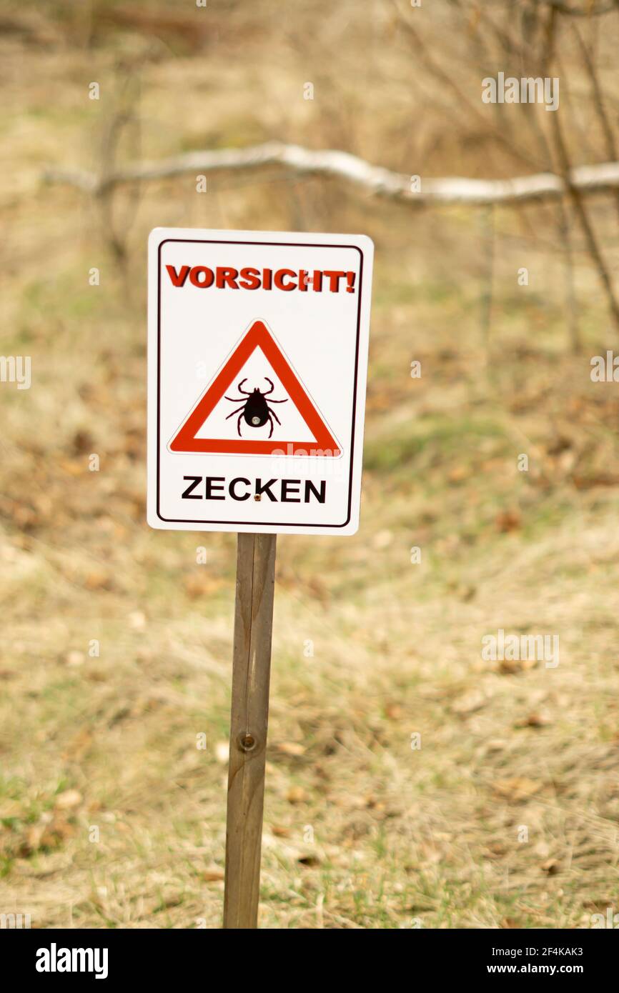 Zecken-Warnschild 'Sicht Zecken' in Deutschland. Übersetzung: Achtung! Vorsicht vor Zecken! Stockfoto