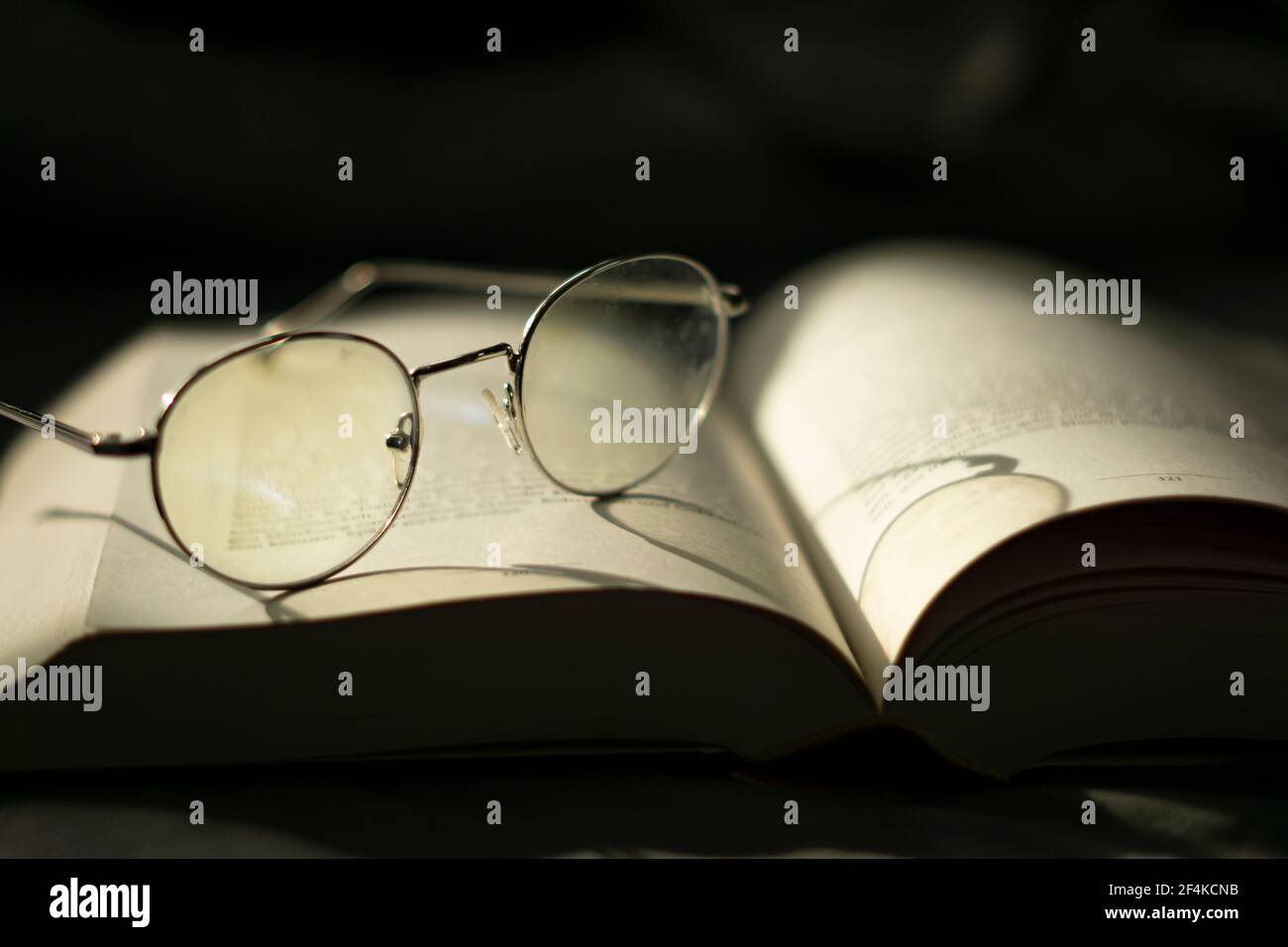 Weisheit und Wissen. Ein Buch lesen. Brillen auf einem Buch abgelegt. Stockfoto