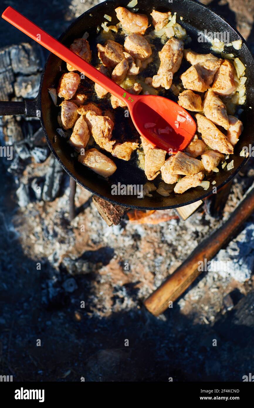 Kochen Huhn in einer Pfanne auf Feuer im Freien Stockfoto