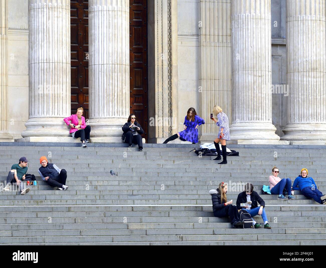 London, England, Großbritannien. St Paul's Cathedral - Menschen entspannen auf den Stufen, während die Kathedrale während der COVID Pandemie, März 2021 geschlossen ist Stockfoto