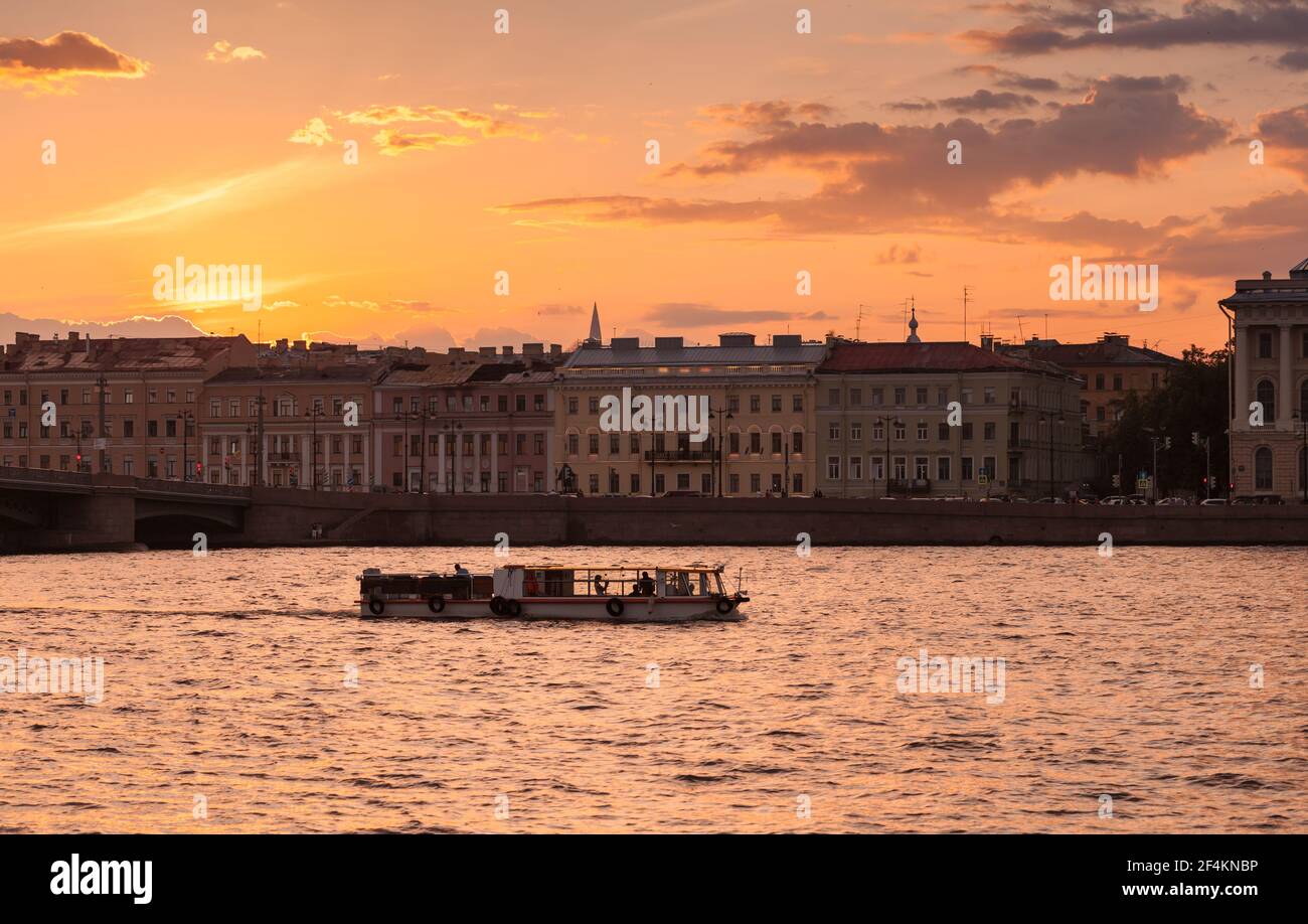 Kleines Touristenboot mit Touristen ist auf einer Bootsfahrt auf dem Fluss Neva in der weißen Nacht in Sankt Petersburg, Russland Stockfoto