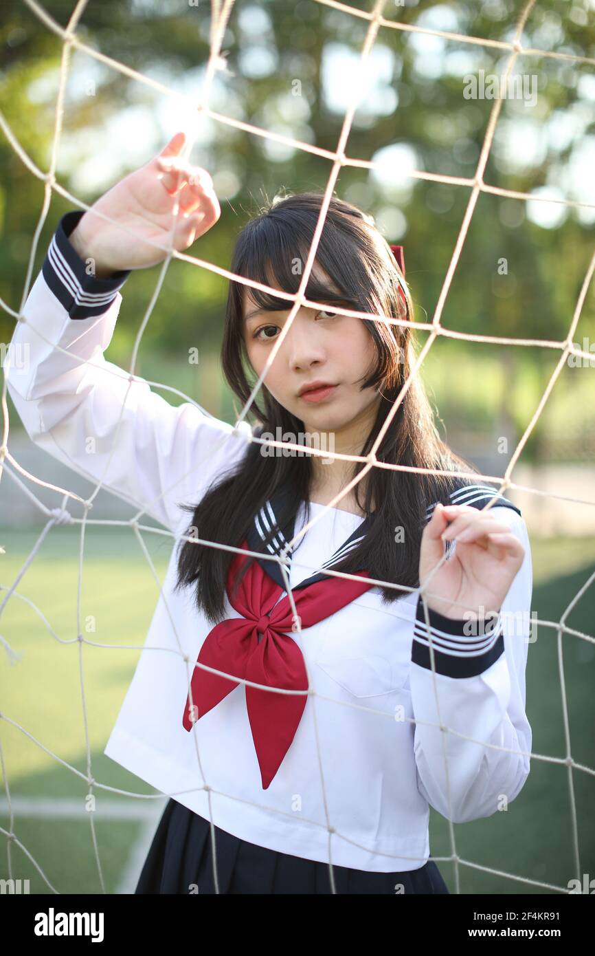Portrait von asiatischen japanischen High School Mädchen Uniform suchen mit Fußball Tornetze Stockfoto