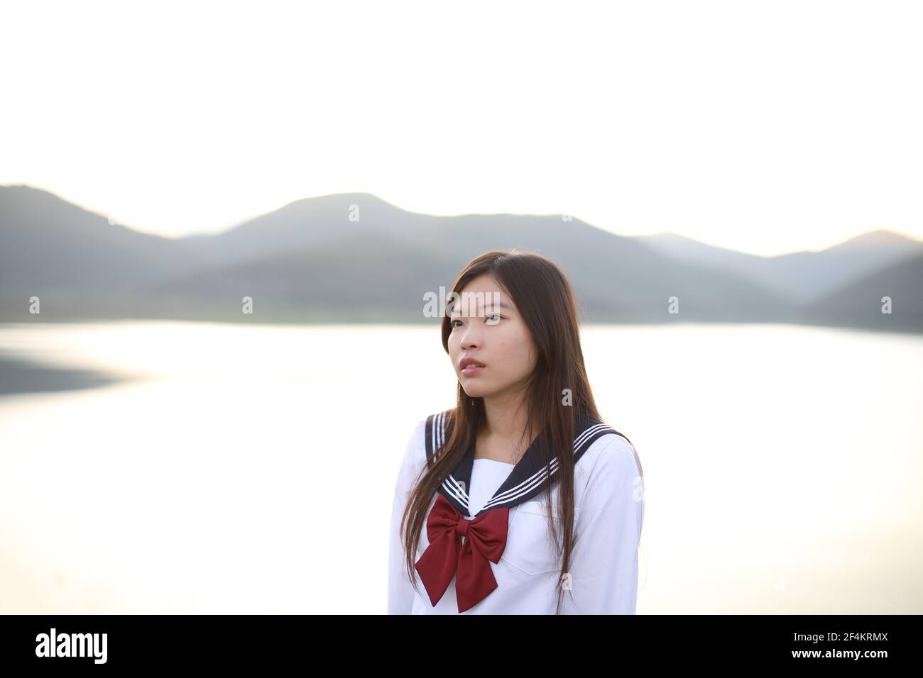 Asiatische Schule Mädchen suchen Berg mit Fluss in Sonnenaufgang Stockfoto