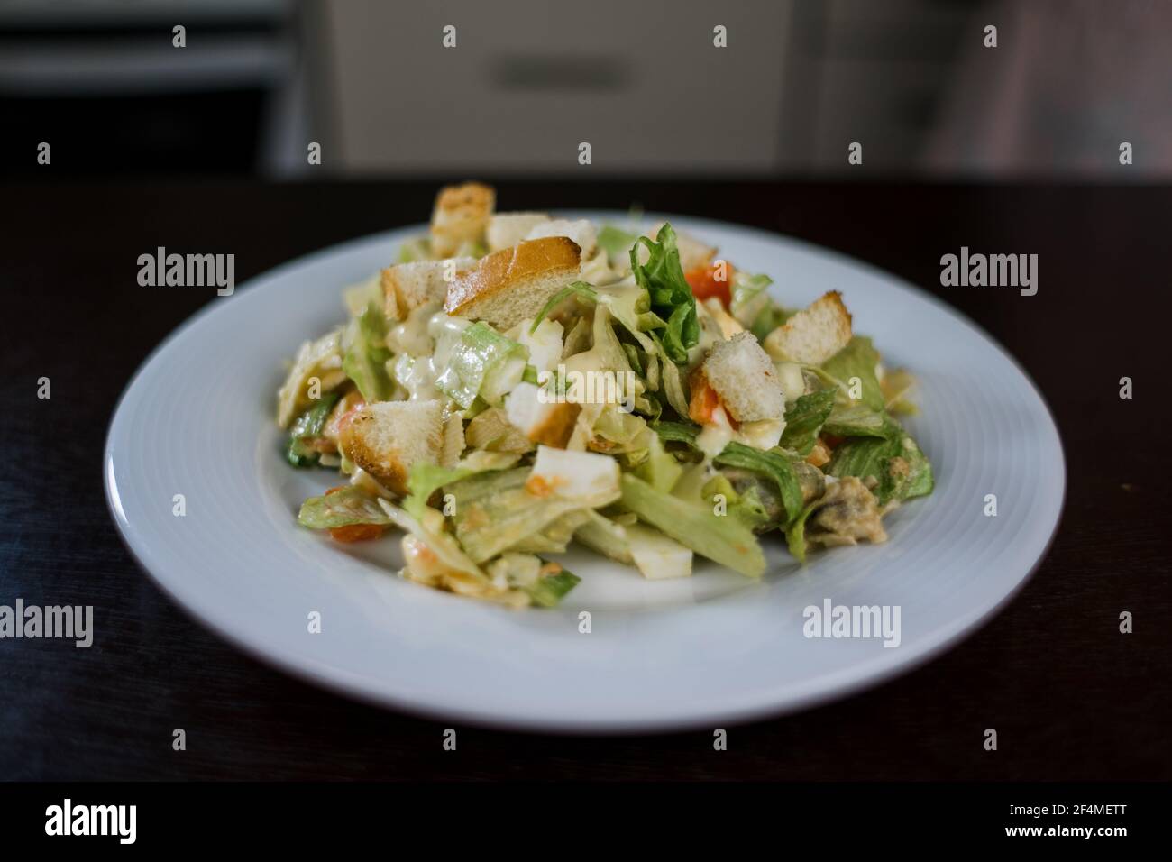 Ein caesar Salat in einem weißen Teller in der Küche Stockfoto