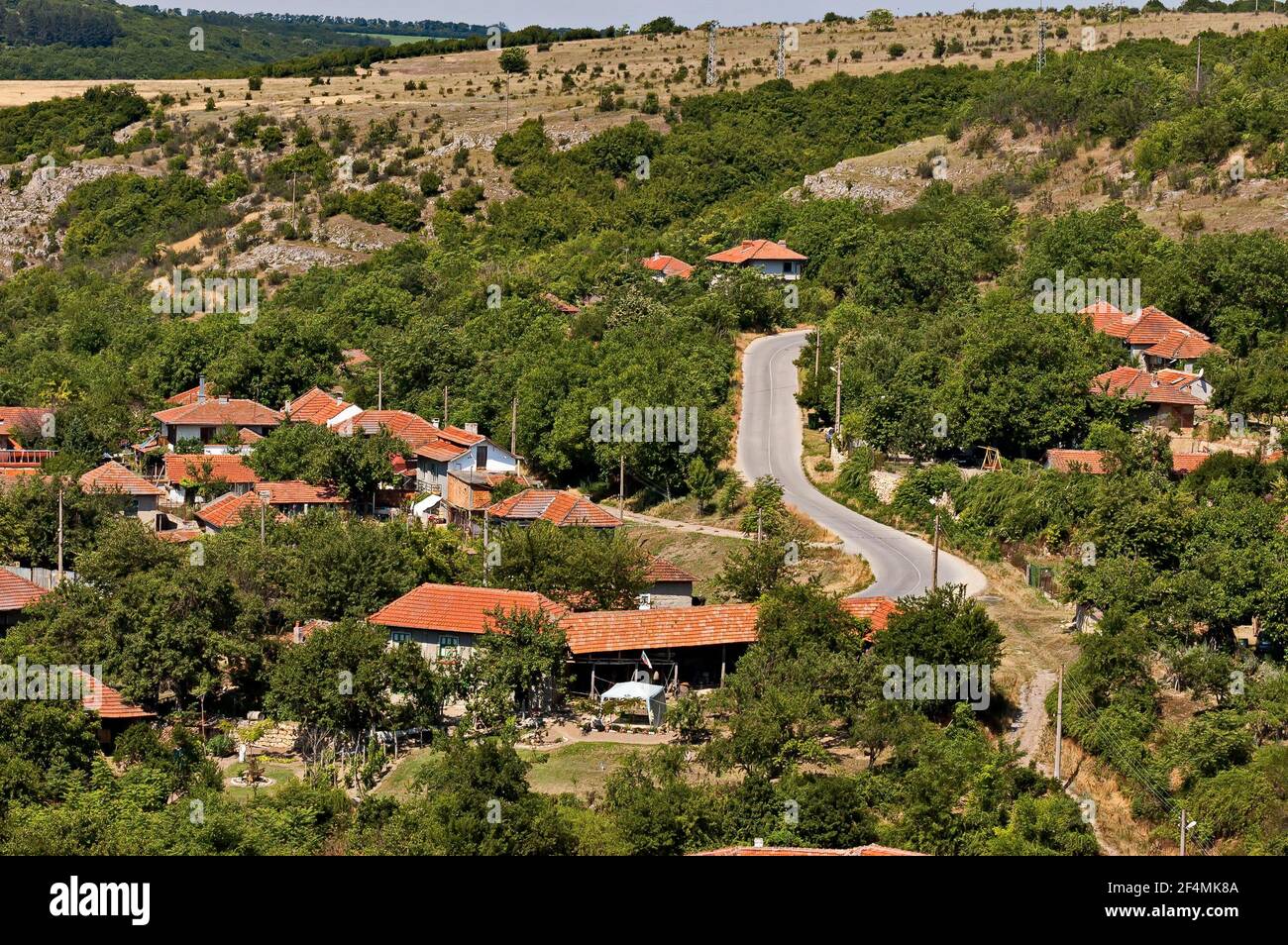 Blick auf das schöne Dorf Nisovo, Bulgarien, unter, über und in den hohen Kalkfelsen, durch herrliche Laubbäume geschützt Stockfoto