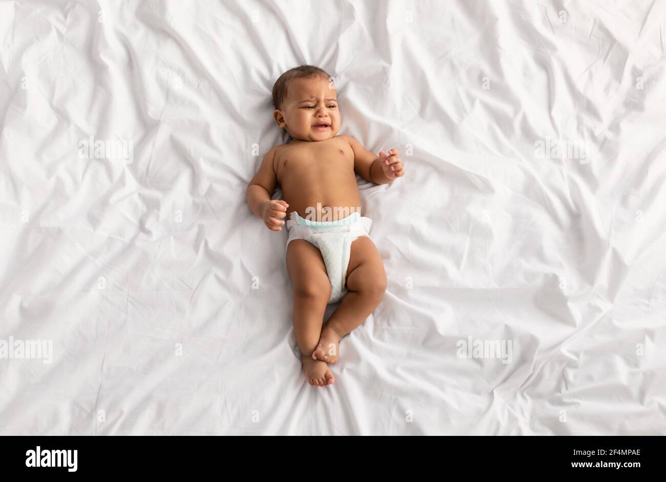Porträt von traurigen schwarzen Baby weinen und liegen auf dem Bett Stockfoto