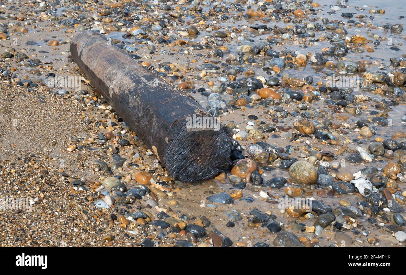 Ein großes Stück rundes Holz auf einem ausgewaschen North Norfolk Beach Stockfoto