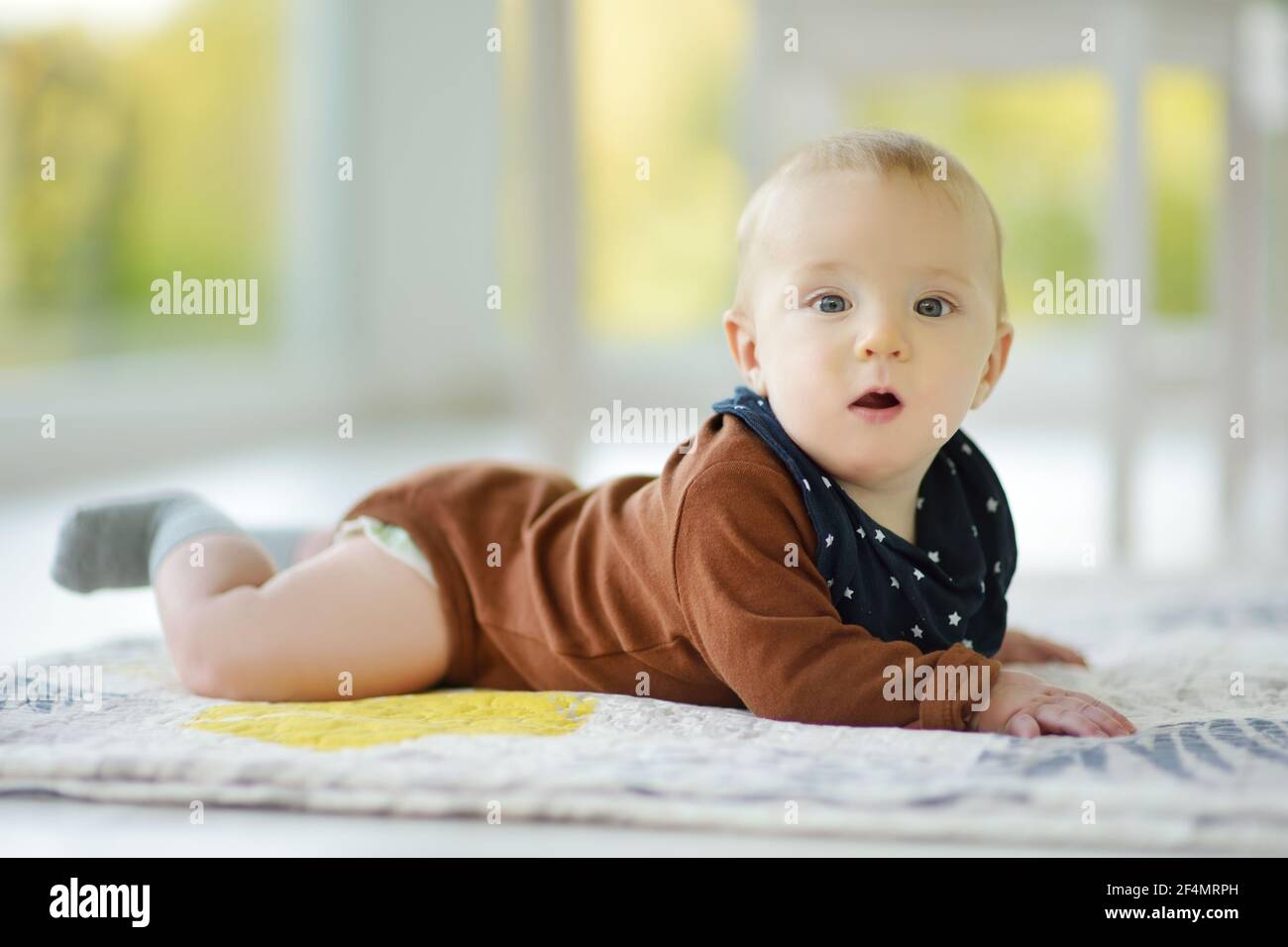 Niedlicher fünf Monate alter Junge, der auf seinem Bauch liegt. Baby während der Bauchzeit. Liebenswert kleines Kind lernen zu kriechen. Stockfoto