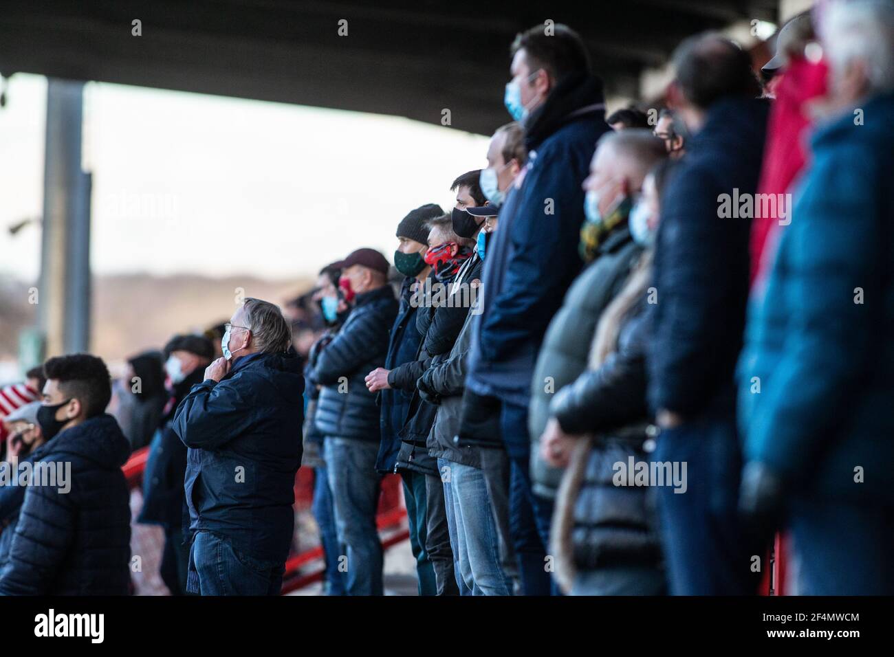 Fans und Zuschauer beobachten Fußballspiele der unteren Liga während der Coronavirus-Pandemie Covid-19 in England, Großbritannien. Tragen von Gesichtsbezügen und Gesichtsmasken. Stockfoto