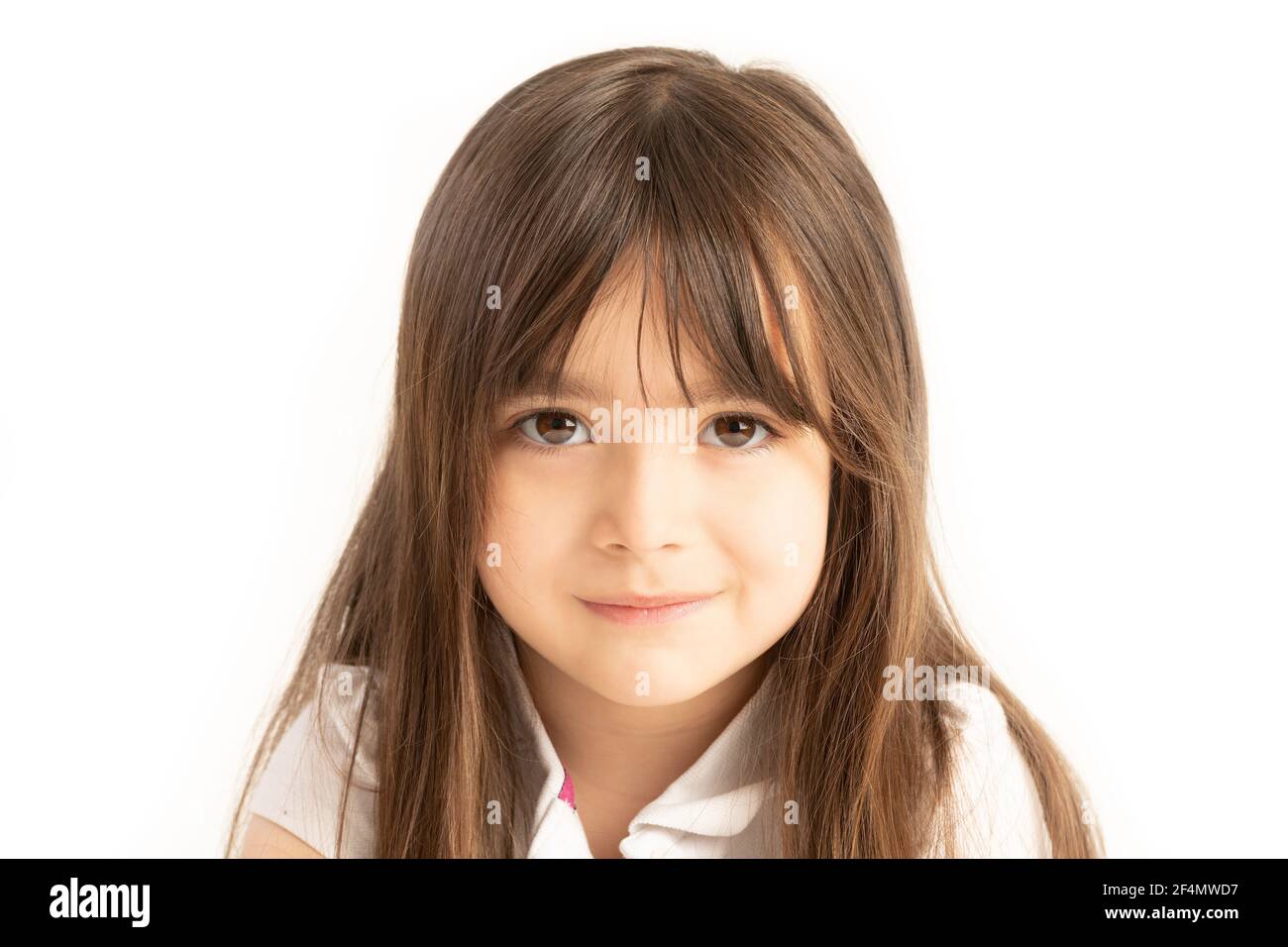 Kleines Mädchen von fünf Jahren schaut direkt in die Augen auf weißem Hintergrund Stockfoto