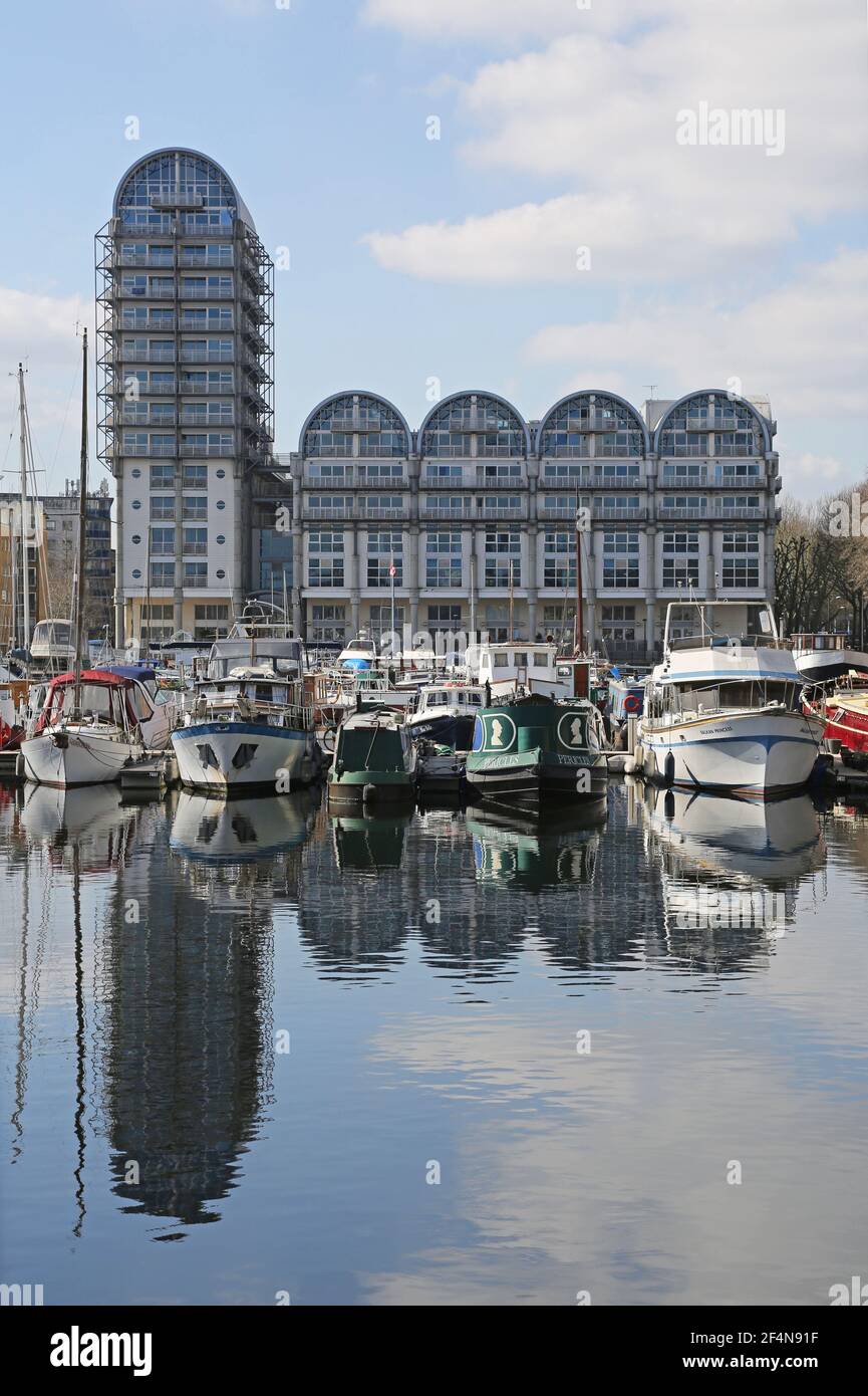 Boote vertäut in South Dock, Rotherhithe, London, UK. Grenzt an die Themse und das Greenland Dock. Baltic Quay 1980s Apartmentblock dahinter. Stockfoto