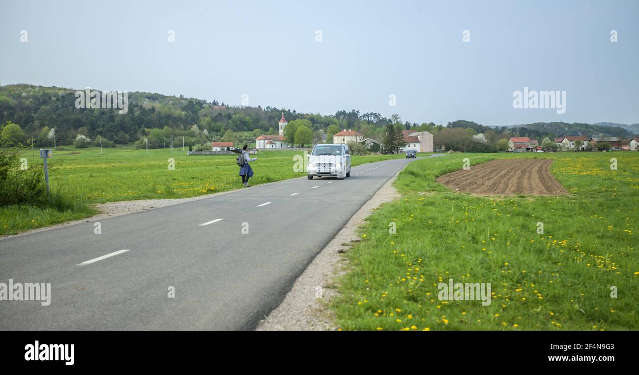 DOMZA, SLOWENIEN - 18. Aug 2019: Junger ausländischer Zughiker wartet auf den Transport Stockfoto
