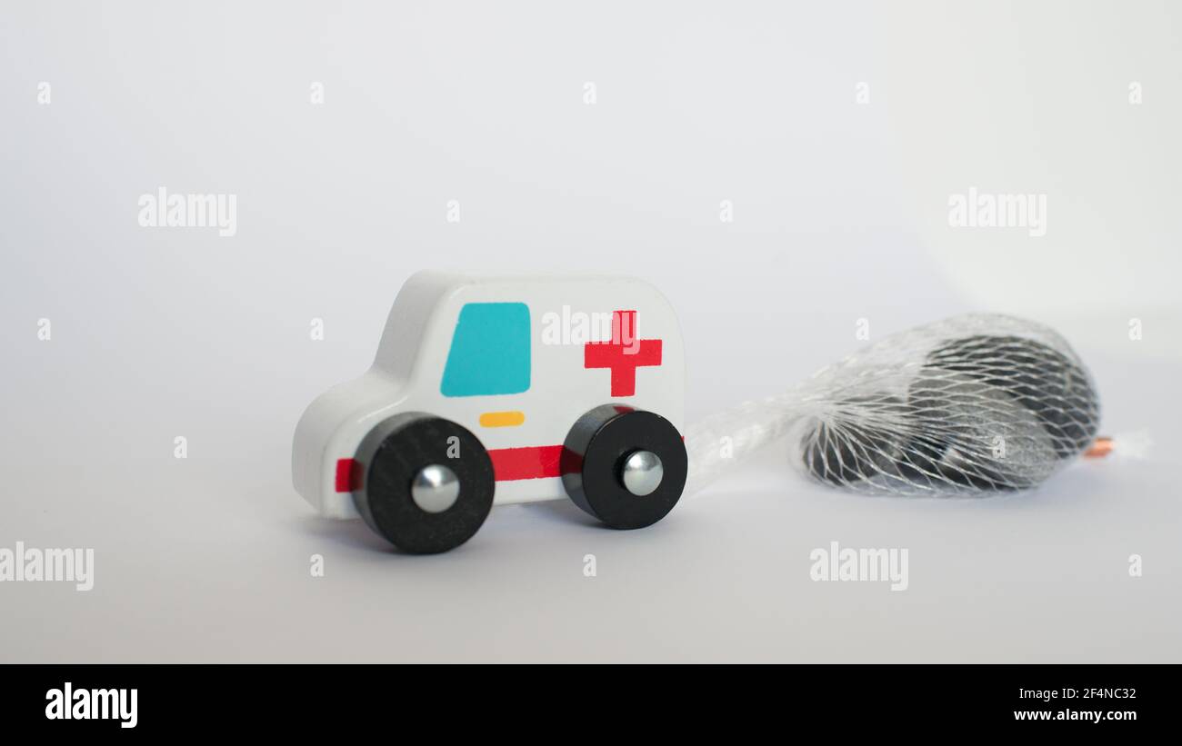 Nahaufnahme eines Rettungsfahrzeugs, das eine schwere Ladung (Steine) zieht. Konzeptionell für die Anstrengungen, die Gesundheitssysteme während der COVID Unternehmen. Weißer Hintergrund Stockfoto