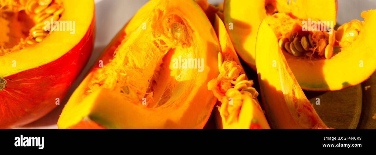 Gelb-orangefarbener Hintergrund. In Scheiben geschnitten ​​pumpkin. Gemüsefahne. Stockfoto