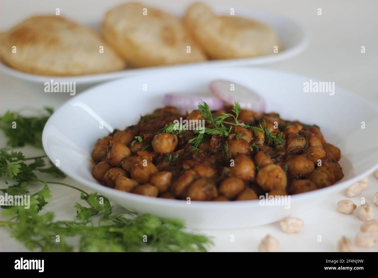 Würzige Kichererbsen-Soße mit gebratenem indischem Fladenbrot. Lokal bekannt als Chole puri. Aufnahme auf weißem Hintergrund Stockfoto