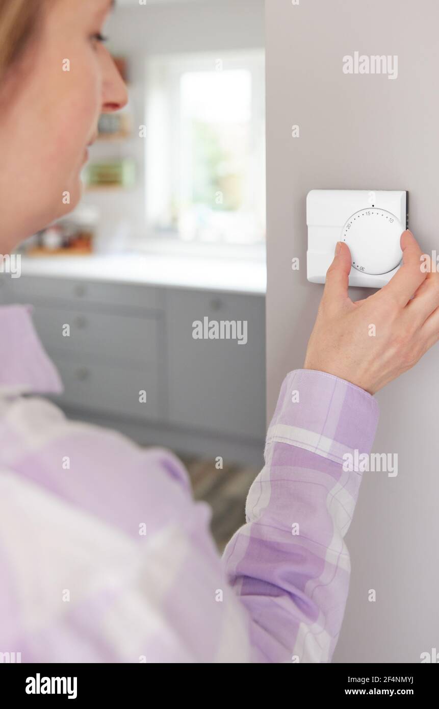 Frau Zu Hause In Der Küche Drehen Nach Unten Zentralheizung Thermostat Um Energie Und Geld Zu Sparen Stockfoto