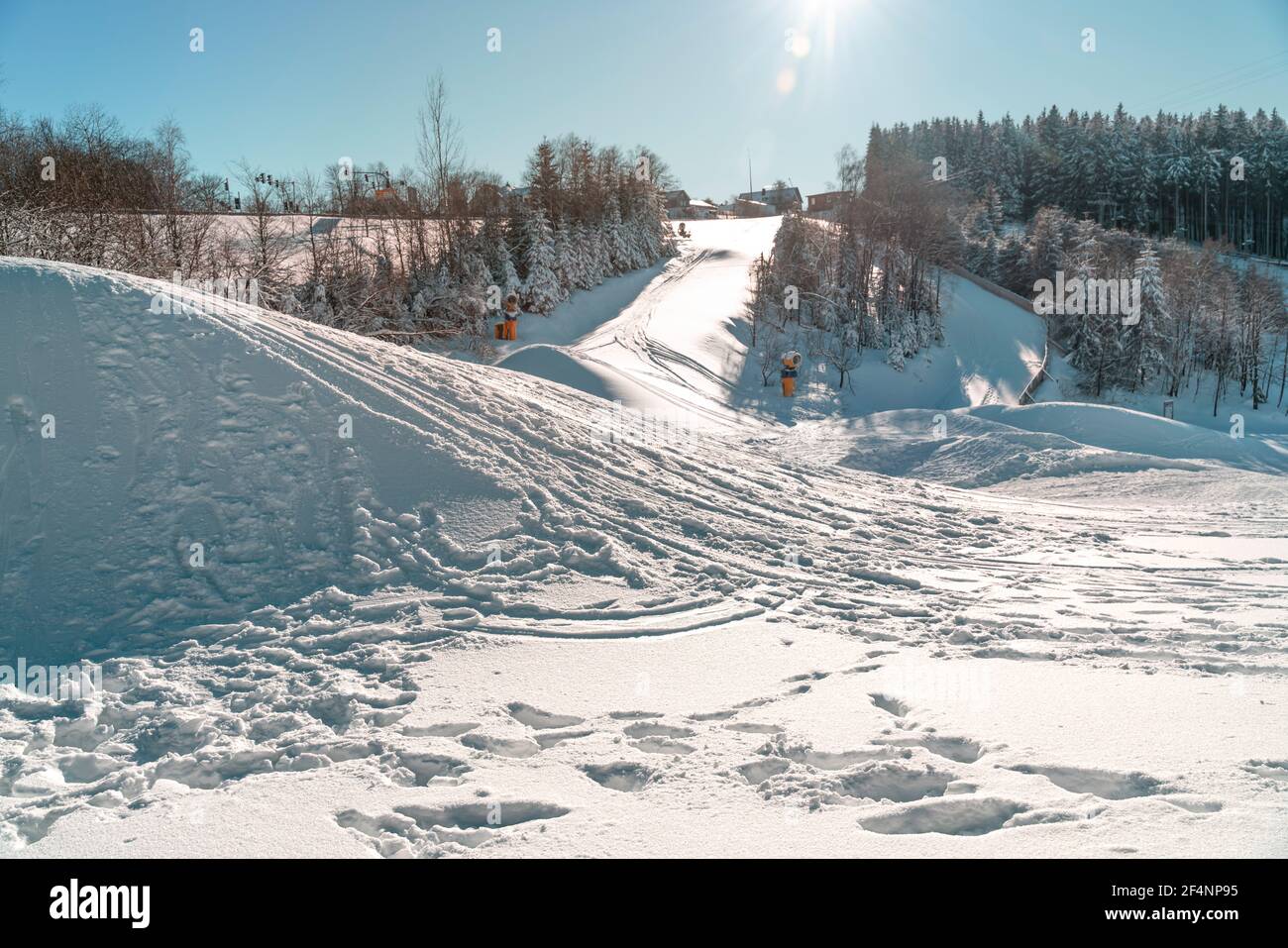 Wintersportgebiet mit Schnee und Sonnenschein. Schneesprünge bieten Möglichkeiten für Ski Cross oder Snowboard Cross. Winterberg, Deutschland Stockfoto