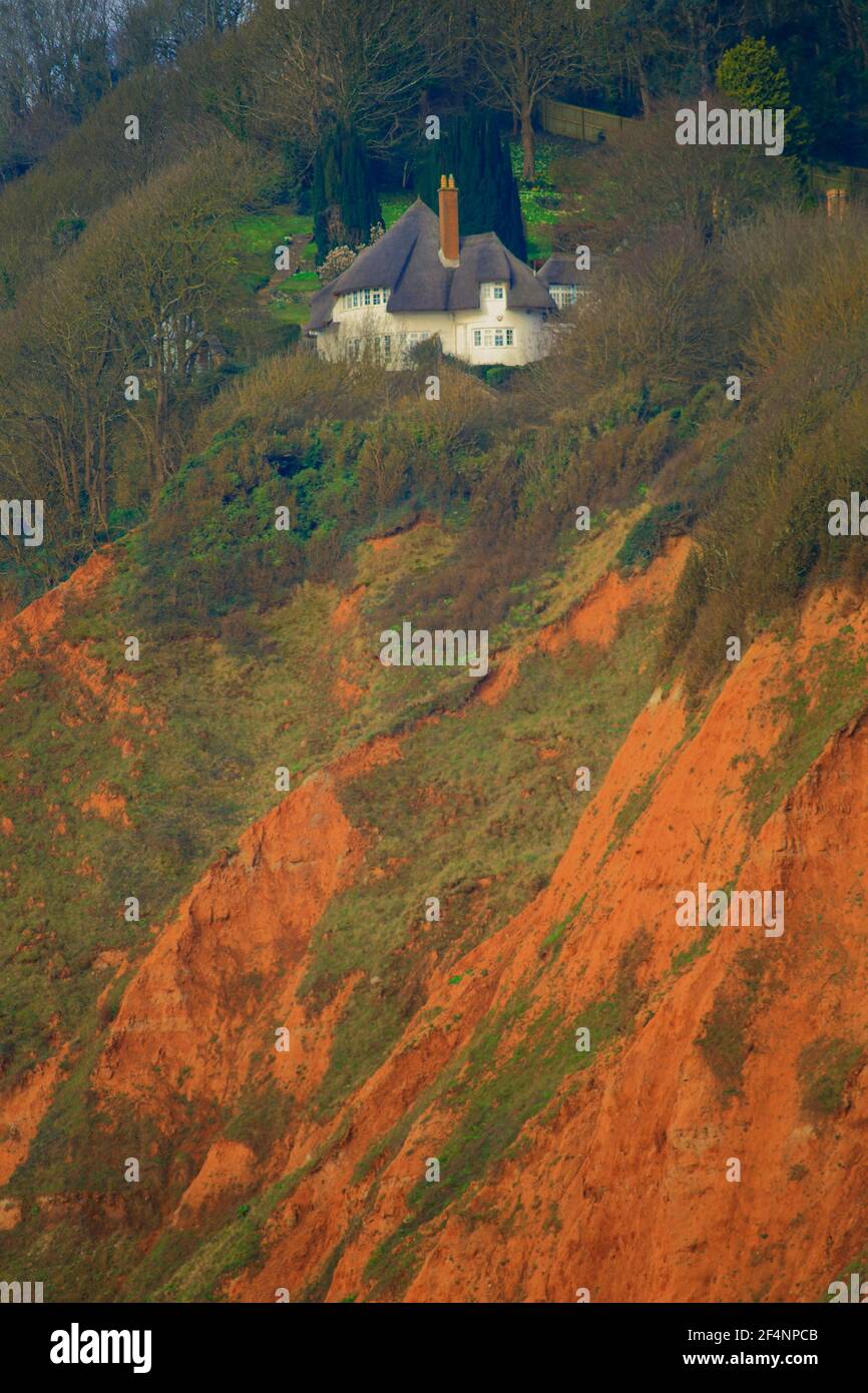 Haus auf der Spitze der roten Sandsteinklippe in Sidmouth, Devon Stockfoto