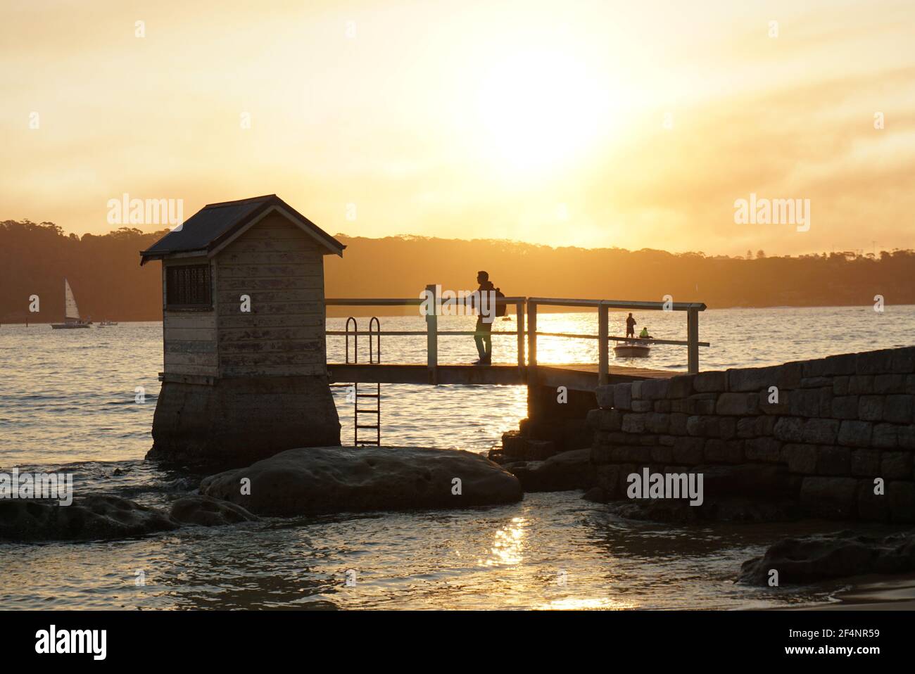 Watsons Bay, Sydney, NSW Australien - Sonnenuntergang hinter einer kleinen Hütte und Brücke in Camp Cove Beach Stockfoto