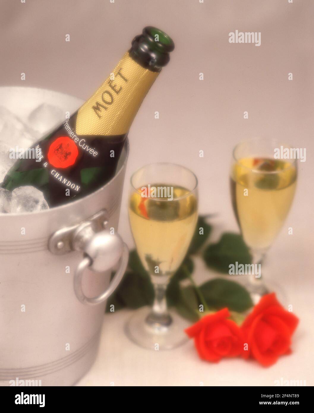 Champagner von Moët & Chandon im Eiskübel mit roten Rosen und Kristallgläsern, Greater London, England, Vereinigtes Königreich Stockfoto