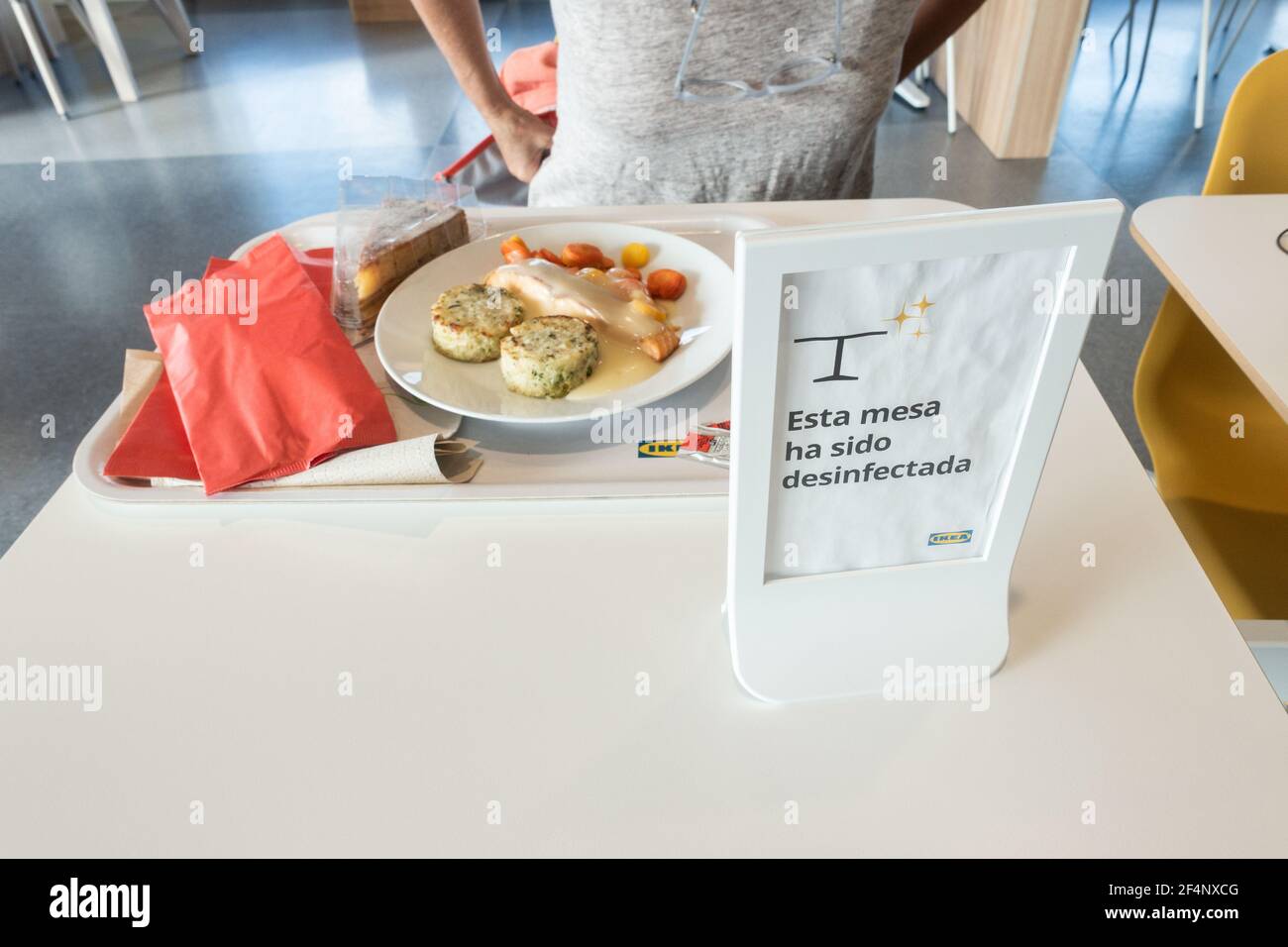 Frau in Ikea Café, Restaurant während Covid, Coronavirus Pandemie. Schild mit der Aufschrift „Diese Tabelle wurde desinfiziert“ Stockfoto