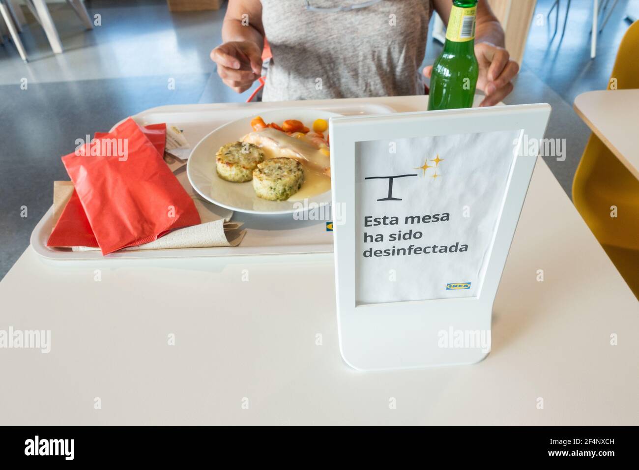 Frau in Ikea Café, Restaurant während Covid, Coronavirus Pandemie. Schild mit der Aufschrift „Diese Tabelle wurde desinfiziert“ Stockfoto
