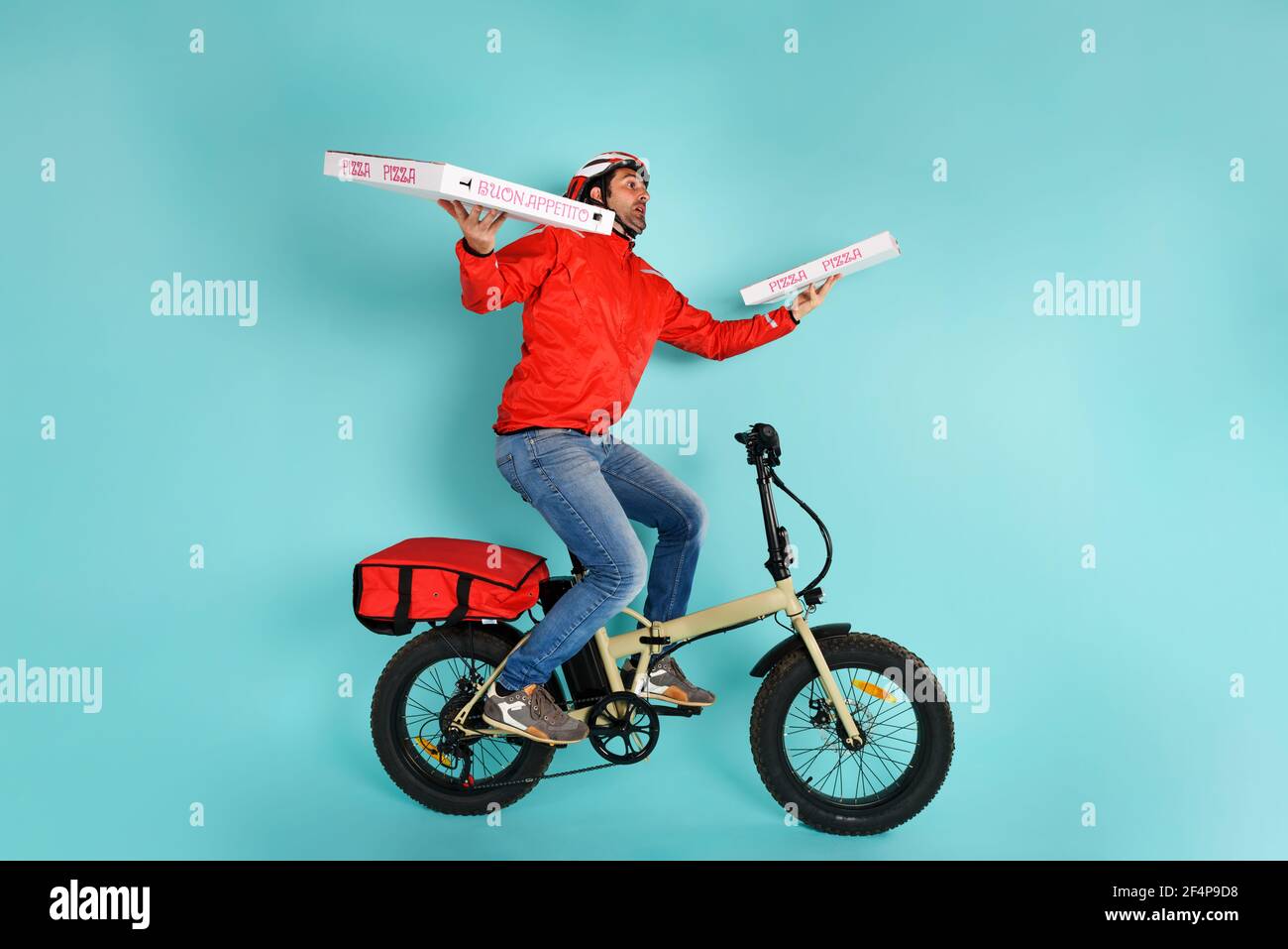 Deliveryman läuft schnell mit E-Bike, um Pizza zu liefern Stockfoto