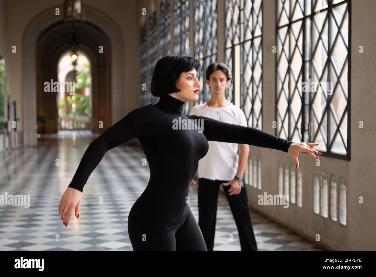 Frau tanzt in der Nähe Mann im Ballsaal Stockfoto