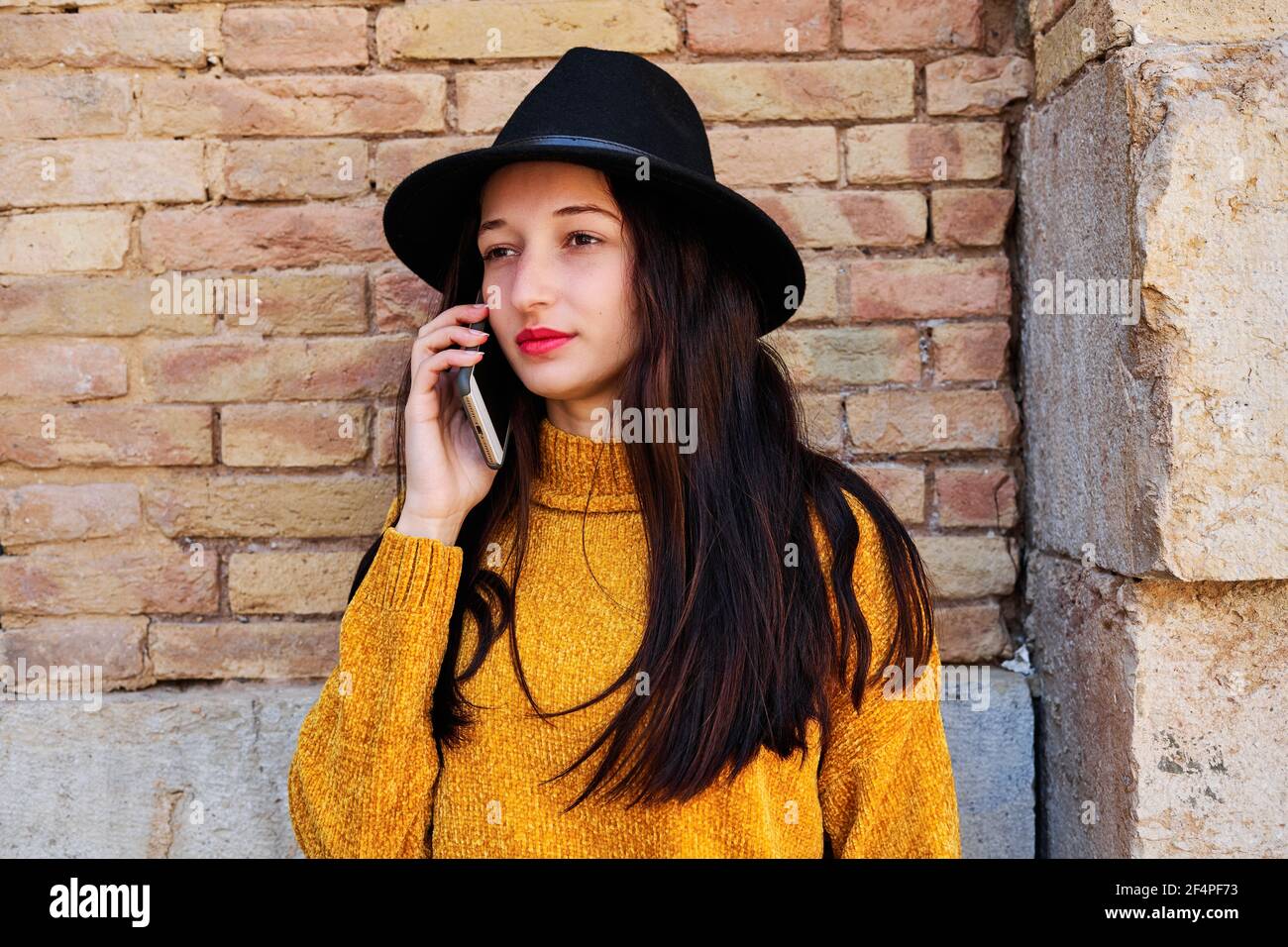 Porträt einer lächelnden jungen Brünette im Gespräch auf dem Handy Telefon Stockfoto