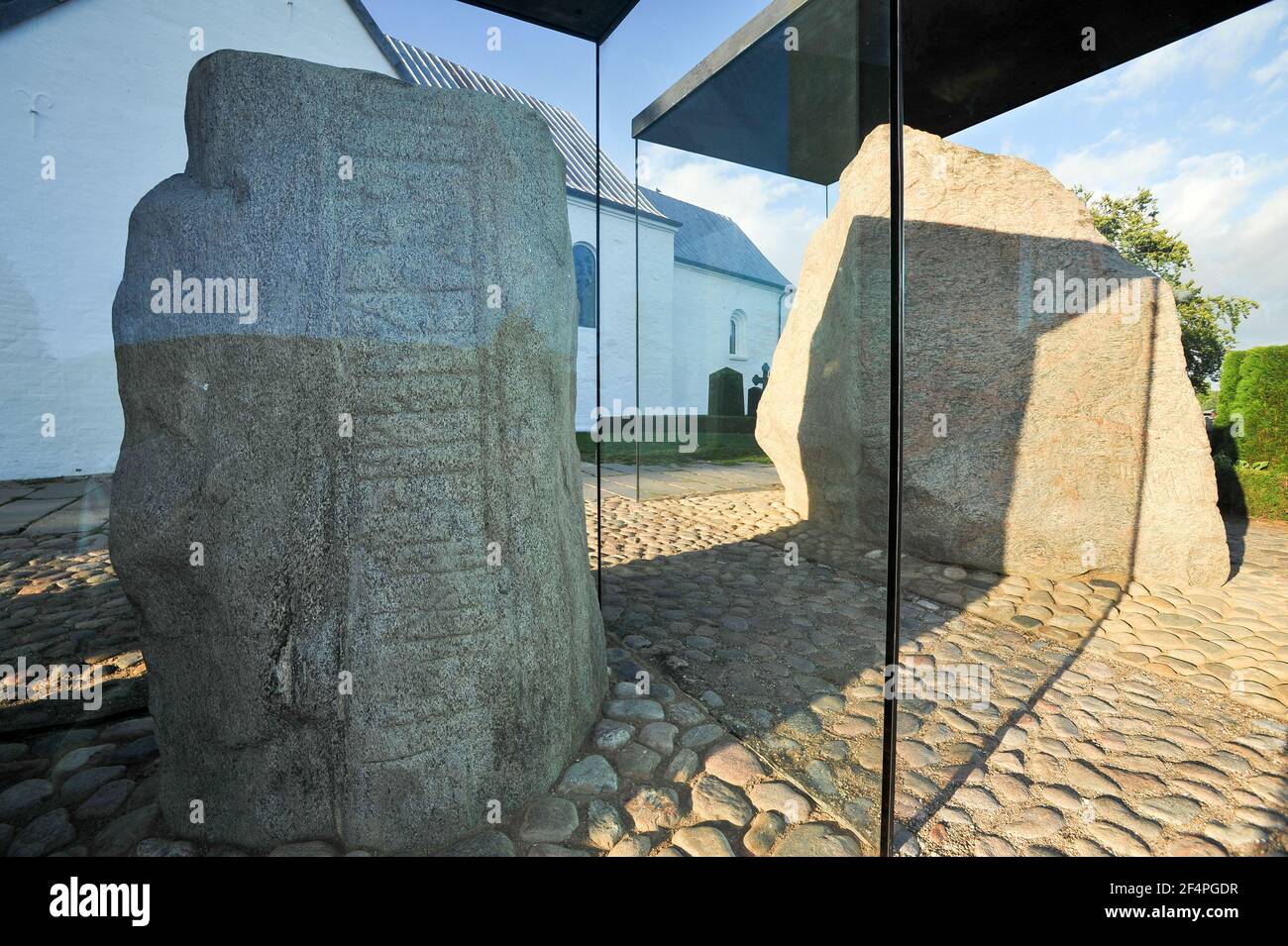 Massive geschnitzten runestones Jellingstenene (Jelling Steine) von X Jahrhundert, auf der linken Seite König Harald von der Bluetooth Gormsson runenstein von 983 in Erinnerung an Stockfoto