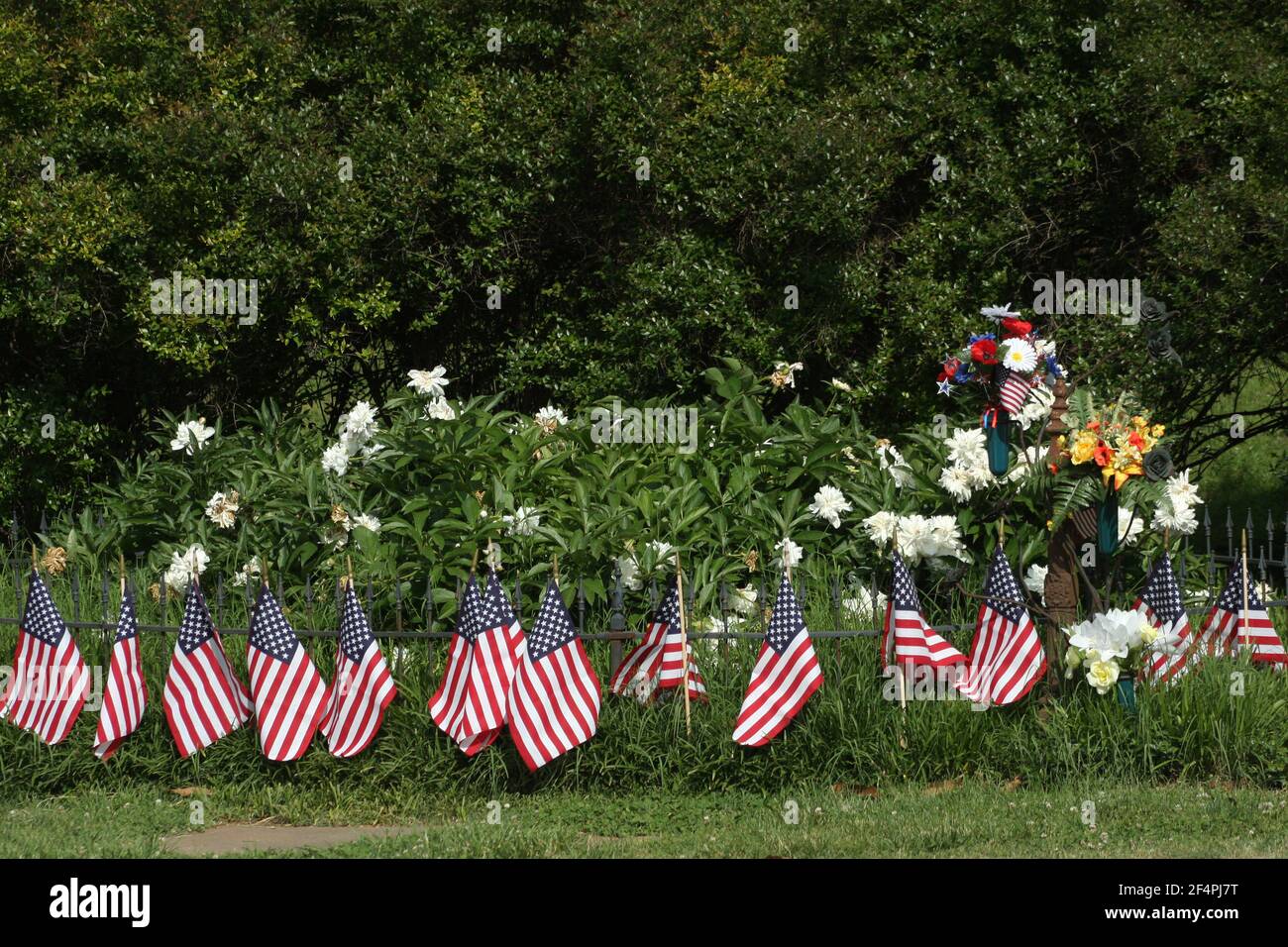 Grab mit Blumen bedeckt und von US-Flaggen umgeben Stockfoto