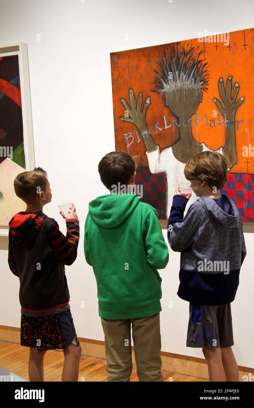 Junge Jungs vor einem Stück sozialer Kunst in einer Galerie in den USA Stockfoto