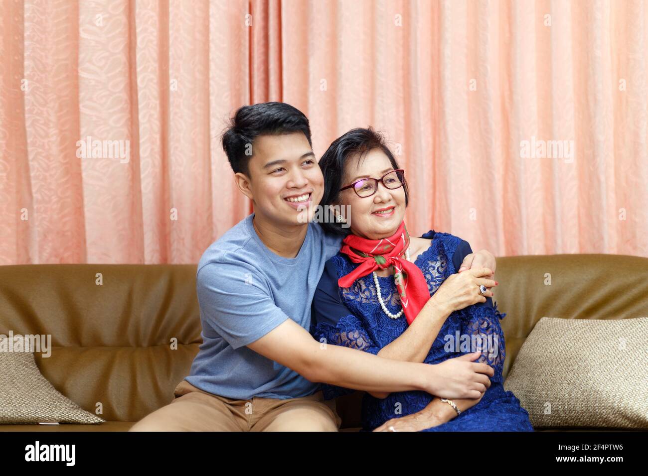 Erwachsener Sohn kommt nach Hause und umarmt Mutter auf die Mütter Tag Stockfoto