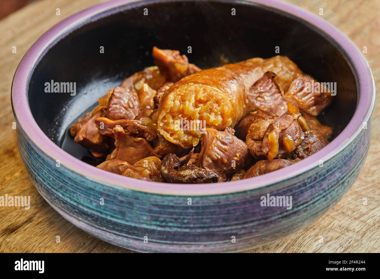 Fleischnavels in einem langsamen Herd mit Wurst in gekocht Den Darm Stockfoto