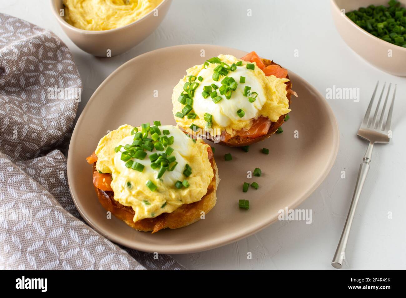 Leckeres herzhaftes Frühstück, Eier Atlantic in einem Teller auf weißem Hintergrund, Runde gebratene Brötchen mit Lachs und Eier Benedikt, Sauce Hollandaise Stockfoto
