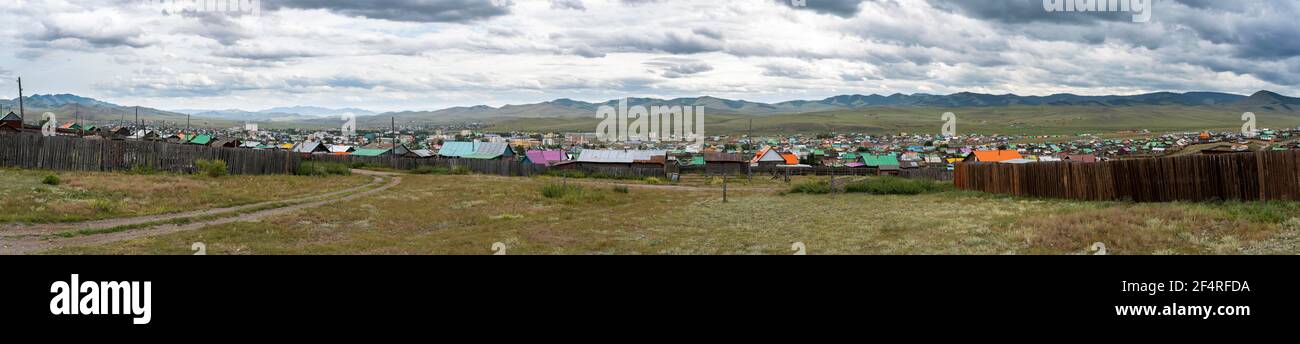 Bulgan, Mongolei - 18. August 2019: Panorama der Stadt Bulgan mit vielen Holzhäusern mit farbigen Dächern der Häuser und einem grünen Feld in Summe Stockfoto