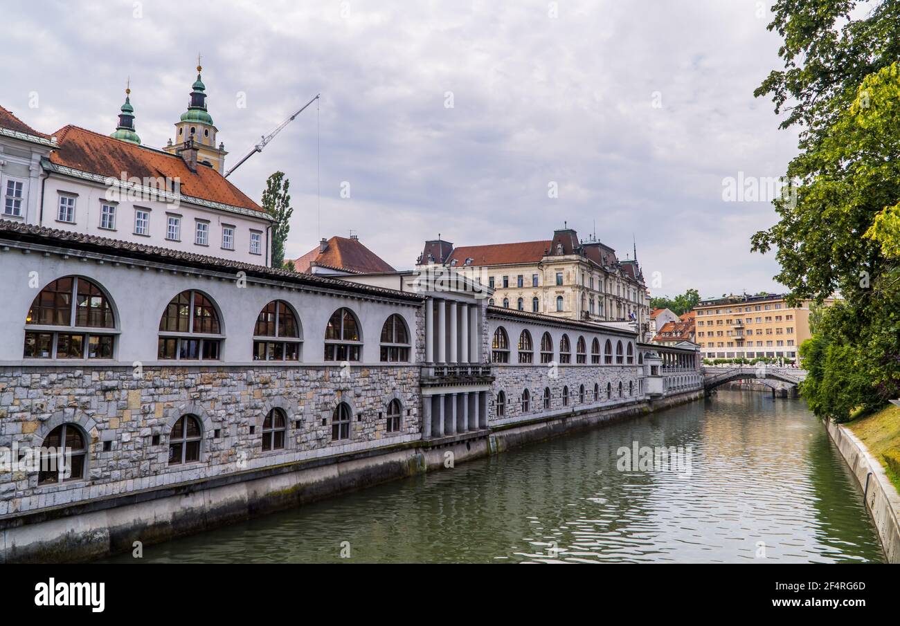 Der Fluss Ljubljanica in Ljubljana, Slowenien mit traditioneller Architektur, Kirchen und einer Steinbrücke Stockfoto