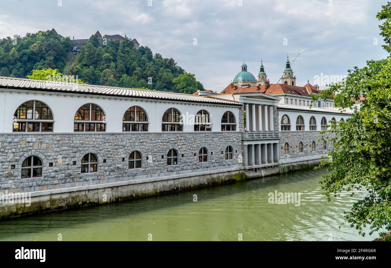 Der Fluss Ljubljanica in Ljubljana, Slowenien mit traditioneller Architektur, Kirchen und einer Steinbrücke Stockfoto